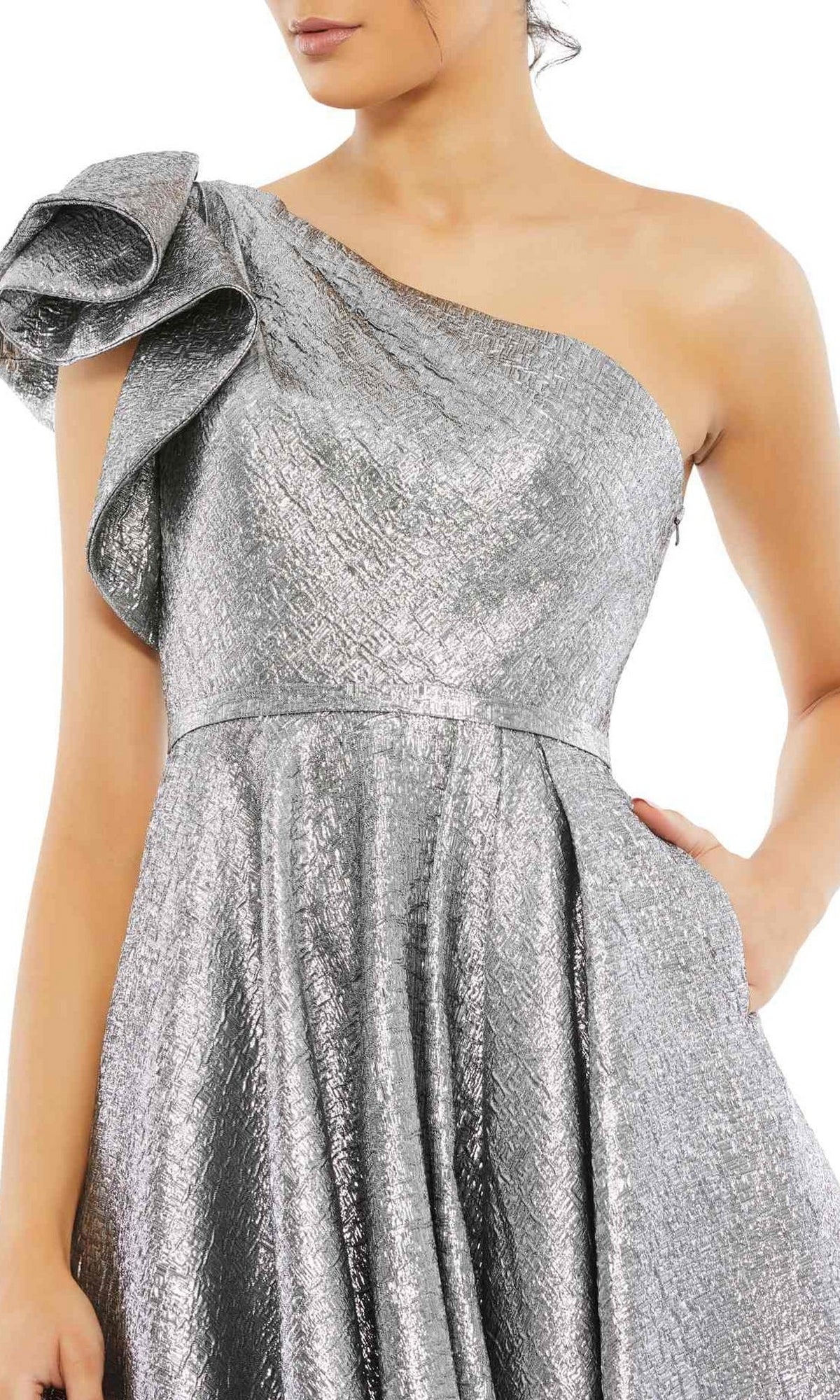 A woman in the Mac Duggal 67906 metallic short wedding-guest dress, featuring a one-shoulder design, textured pattern, and ruffled sleeve—a striking knee-length choice for special events.